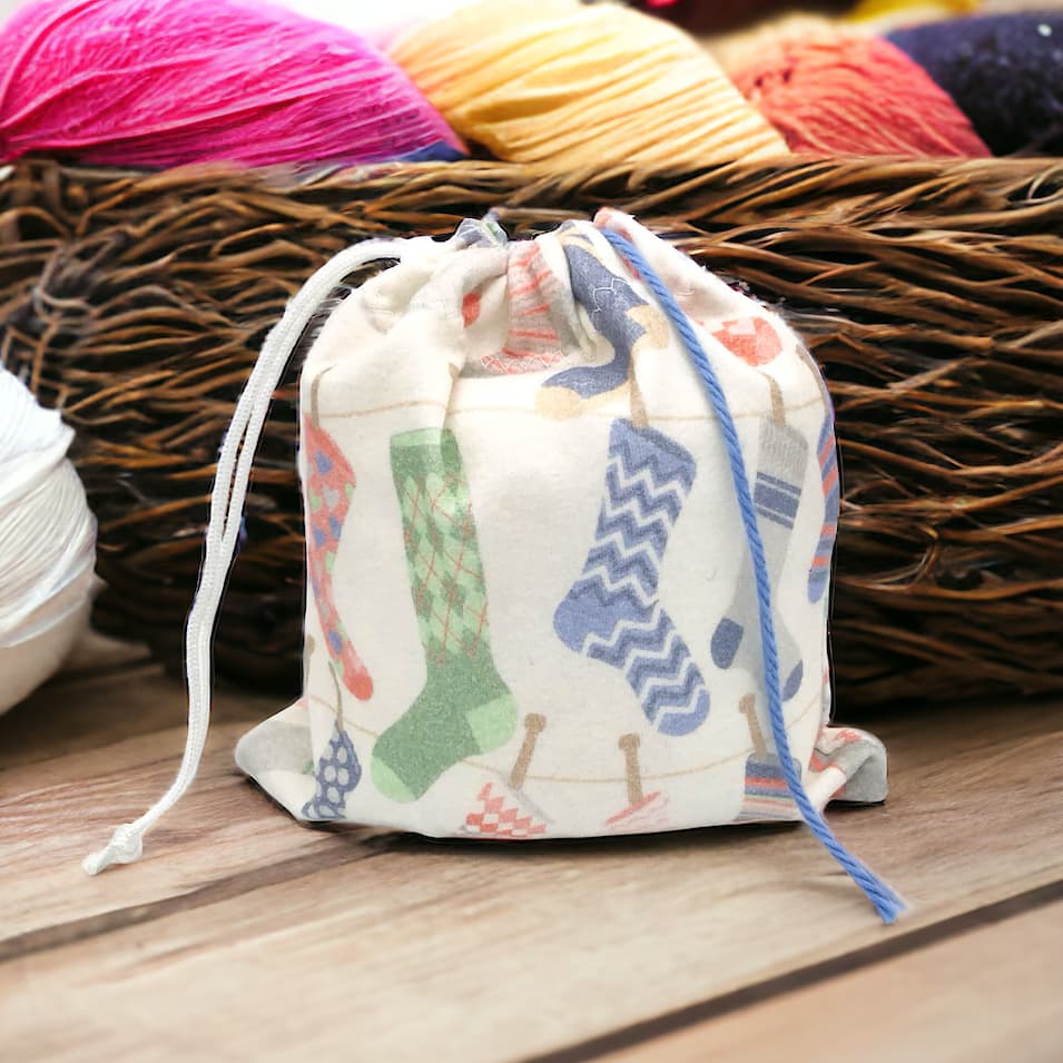 cotton yarn holder with sock design sitting in front of basket of yarn